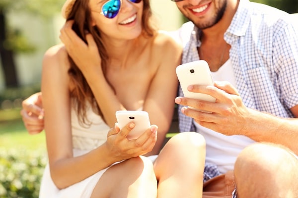 Happy couple using smartphones
